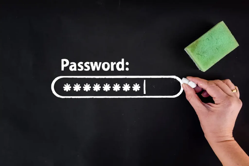 Mão escrevendo a palavra Password e uma série de asteriscos em uma barra de senha com giz em um quadro negro