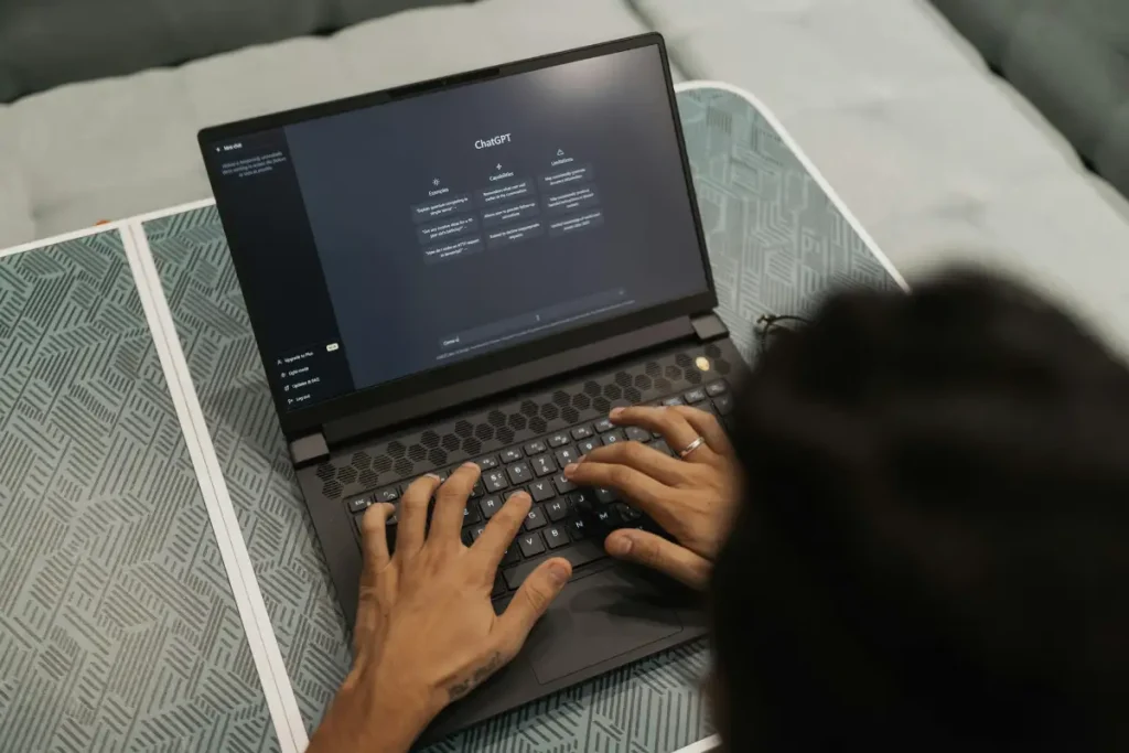 Pessoa digitando em um notebook com a tela do ChatGPT aberta no modo escuro